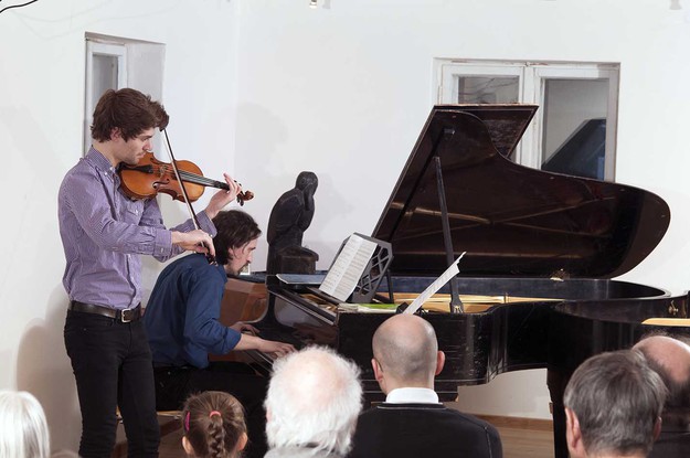 Violist und Pianist spielen vor gefesseltem Publikum.